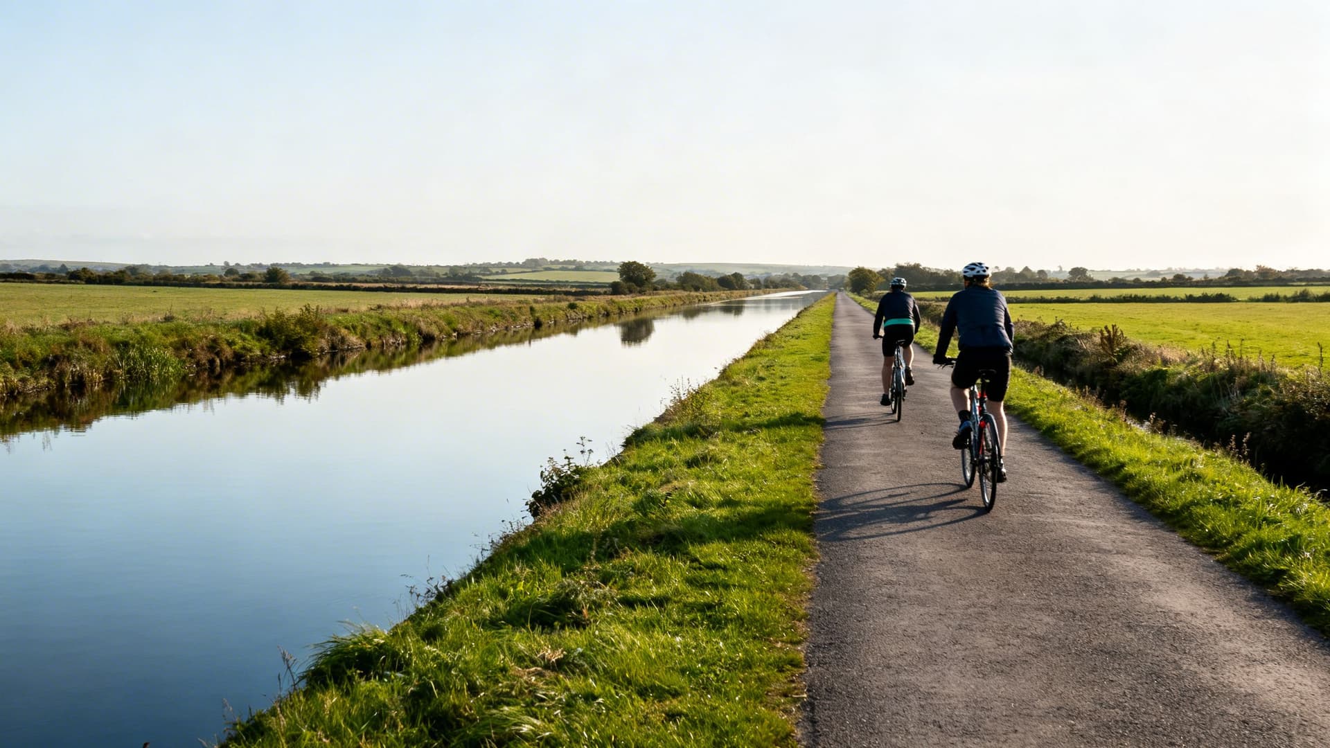 Lough Derravaragh in County Westmeath at dawn, calm dark water reflecting the wooded shoreline in the midland drumlin landscape