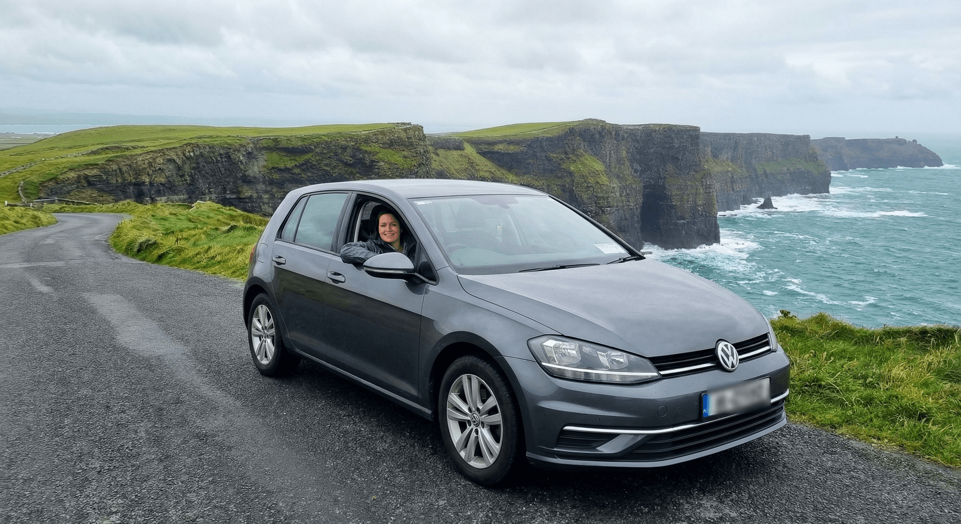 Rental car on scenic Irish coastal road