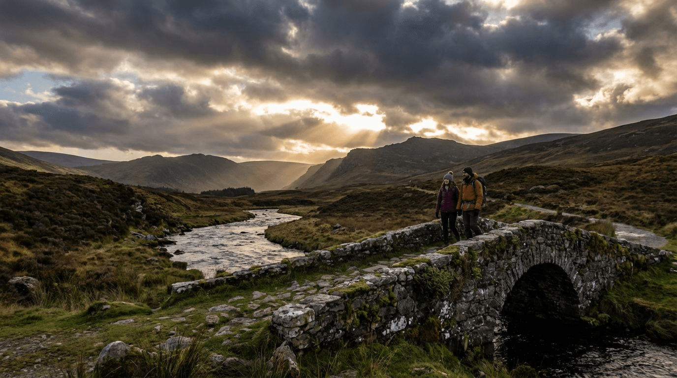 A couple on a stone bridge in the Wicklow mountains, dramatic sky with sun breaking through