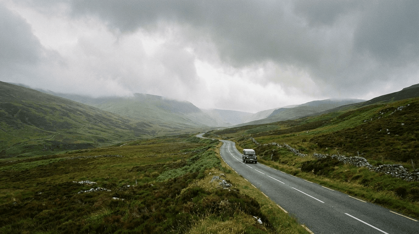The Wicklow Gap mountain road with rolling green hills, dramatic clouds, a winding road cutting through the valley