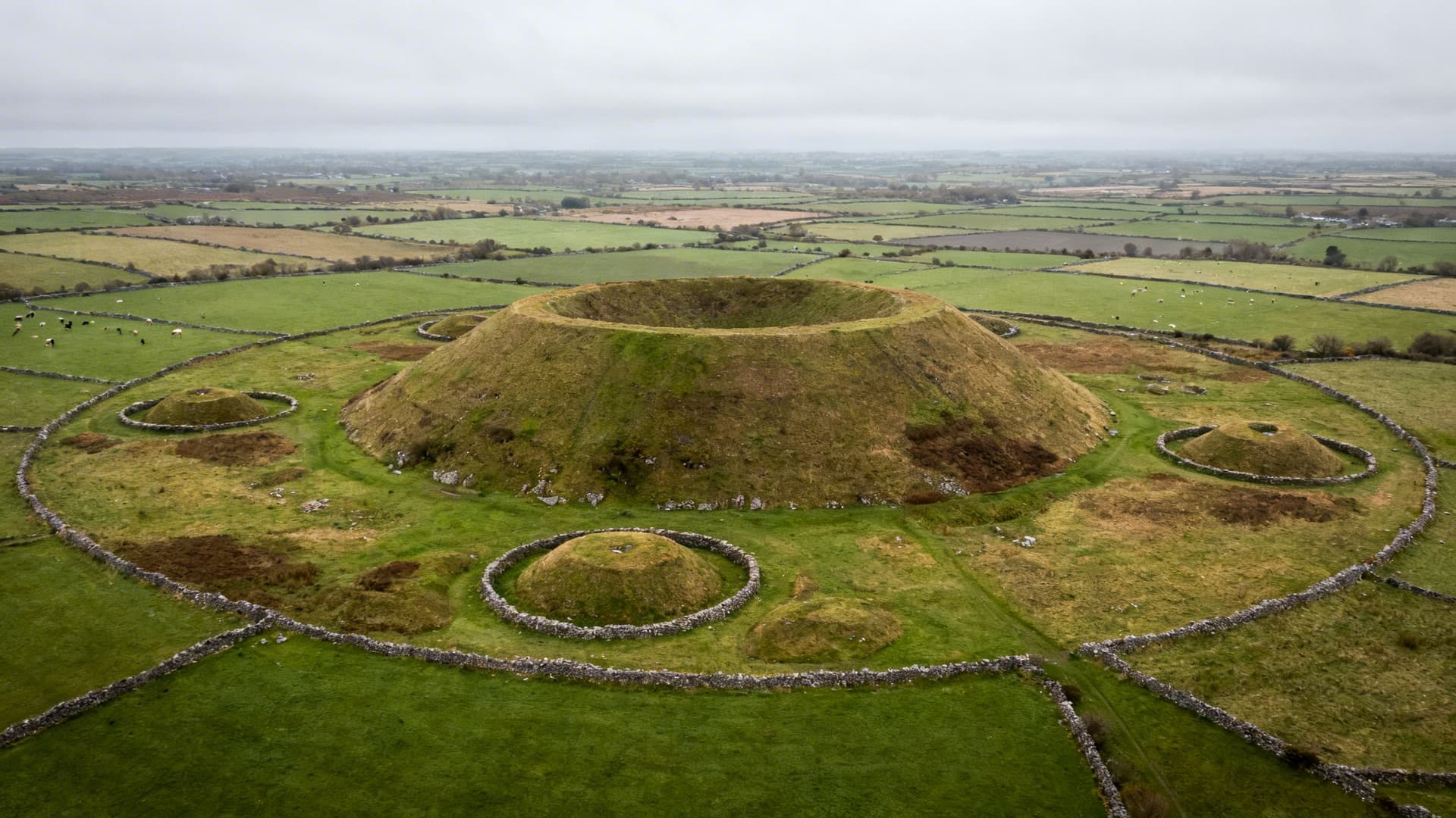 Ancient ceremonial mound and archaeological earthworks spread across green farmland at Rathcroghan in County Roscommon